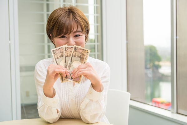 嬉しそうにお金を持つ女性